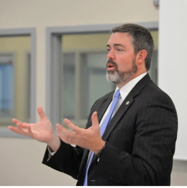 David speaking at an indoor event.