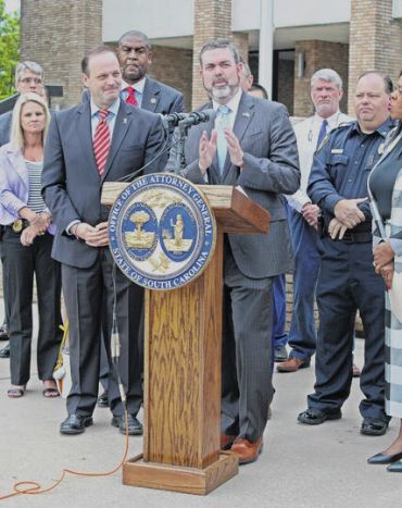 David speaking at a podium alongside officials and law enforcement.